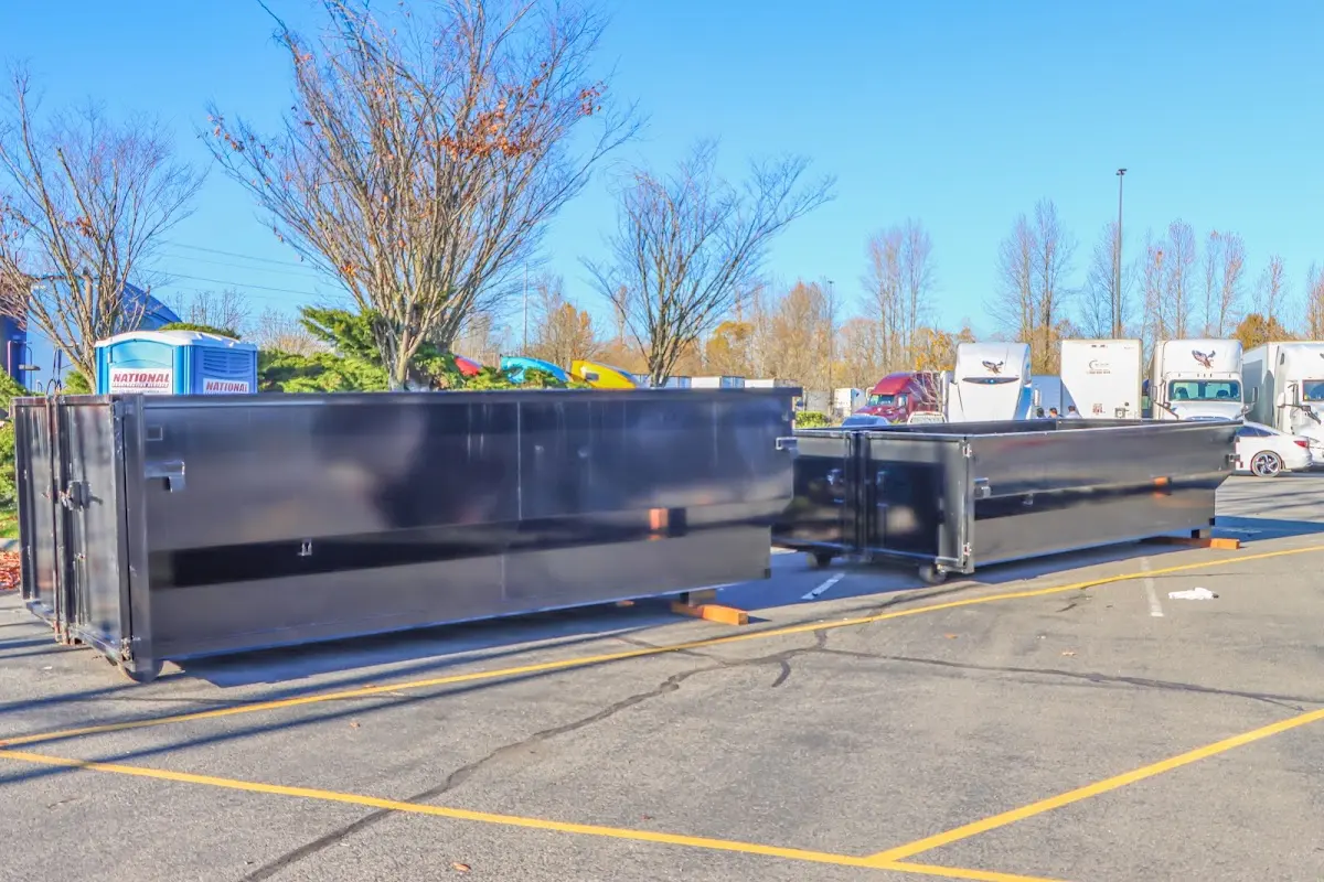 Professional dumpster rental service with roll-off container on residential driveway in Tipton